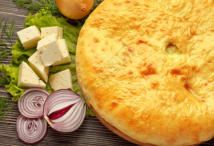奥塞梯美食卡丁兹丁洋葱奶酪派木制表高清图片