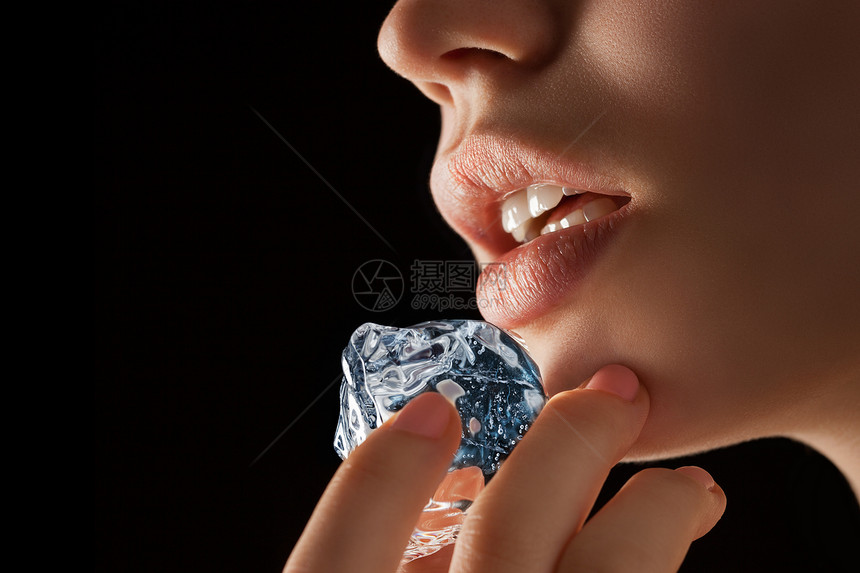 张冰块通往嘴唇的路上用手指夹住的照片图片