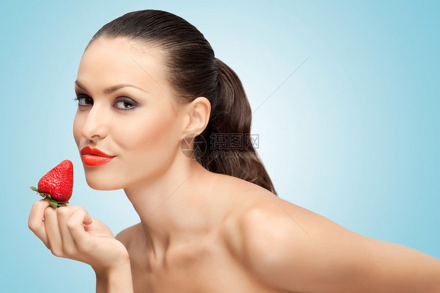 个美丽的女孩用只手着个多汁的草莓靠近她的嘴唇诱惑的创造肖像图片