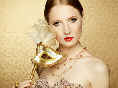 美丽的轻女人戴着神秘的金色威尼斯具时尚照片图片