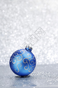 银色闪光背景上蓝色闪亮的诞球背景图片