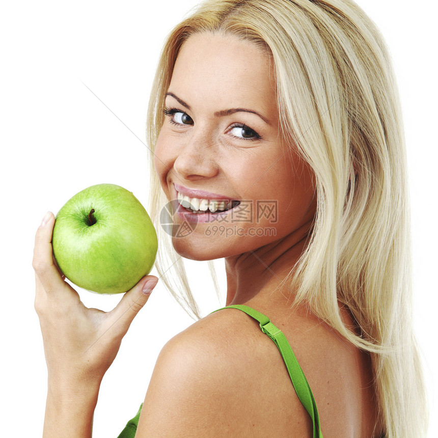 轻微笑的女人着绿色的苹果,孤立白色上图片