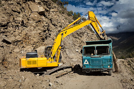 洛曼拉土地喜马拉雅山的道路建设挖掘机卡车印度希马查尔邦拉胡尔山谷背景