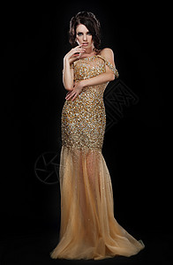 精致于型毛笔字正式派迷人的时尚模特穿着优雅的金色连衣裙,而黑色背景