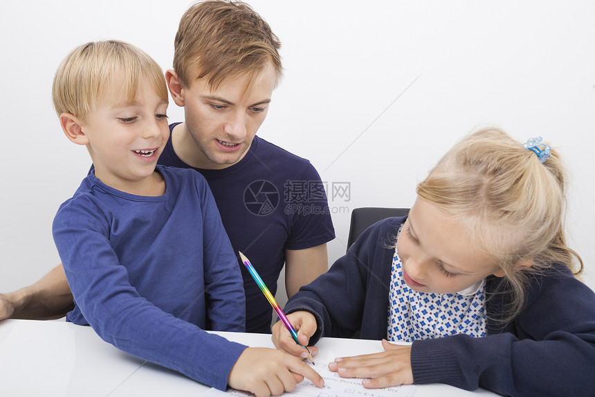 父亲儿子看着桌子上学的女孩图片