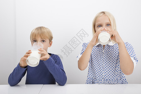 儿童餐桌上喝牛奶的肖像图片