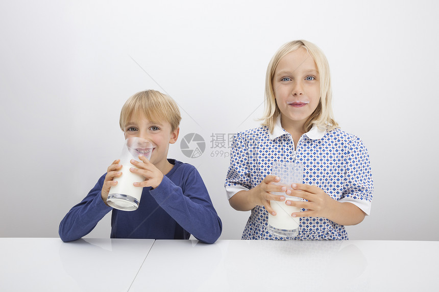 儿童餐桌上喝牛奶的肖像图片