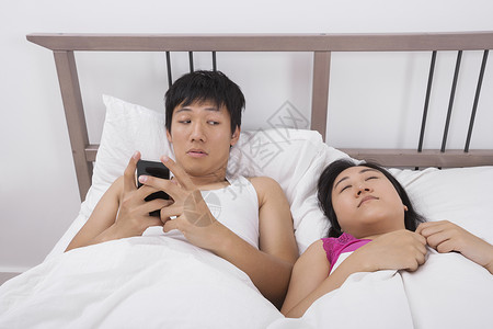 男人用手机看女人睡床上图片