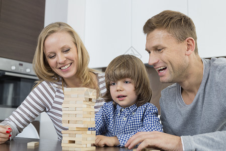 快乐的父母儿子家里玩木块图片