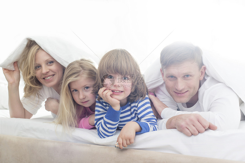 躺床罩下的快乐父母孩子的肖像图片