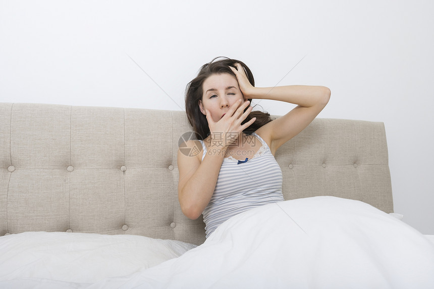 困倦的女人床上打哈欠图片