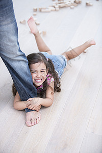 快乐女孩的肖像被父亲拖硬木地板上图片