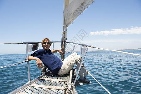 坐游艇船头的快乐男人的全长图片