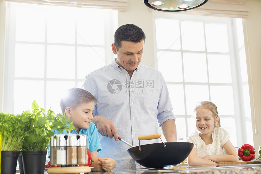 孩子们看着父亲厨房准备食物图片