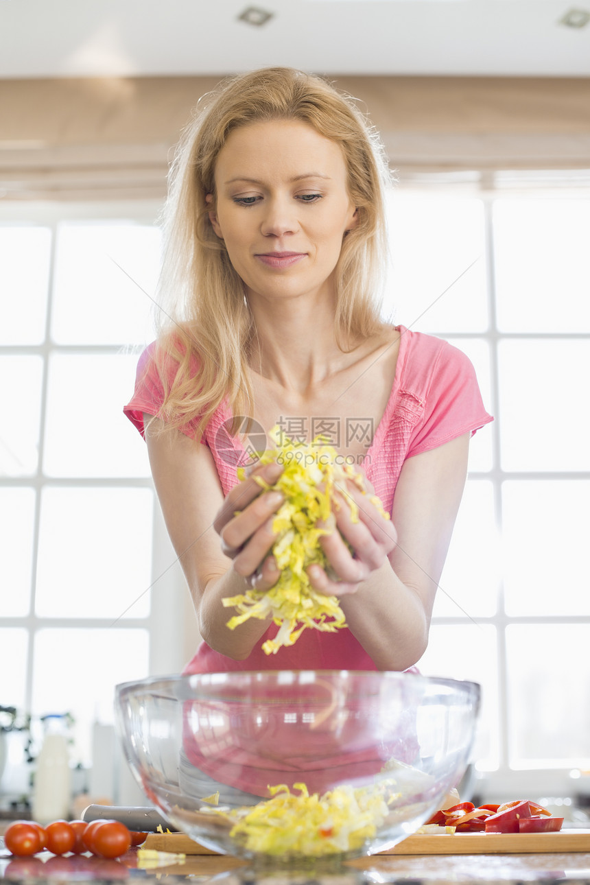 中妇女厨房准备蔬菜沙拉图片