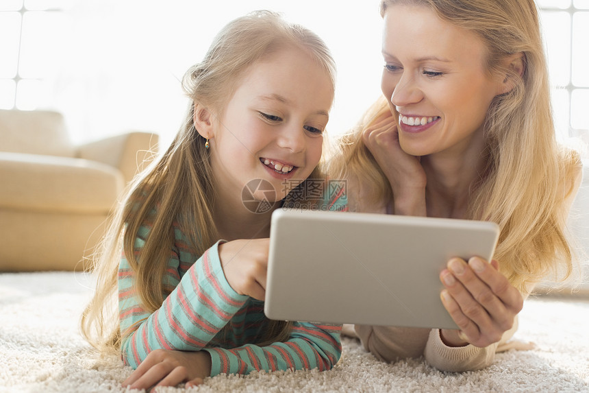快乐的母女家里用数字平板电脑图片