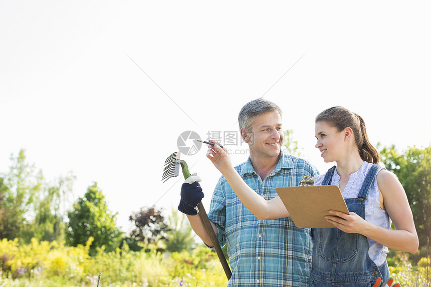 快乐的女主管向苗圃的园丁解释些事情图片