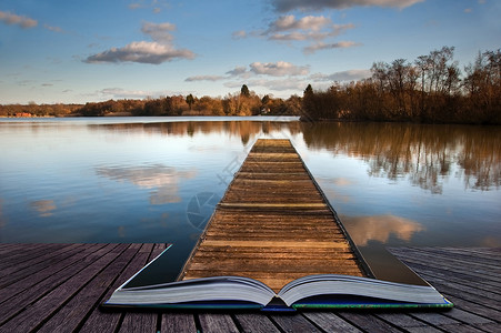 美丽的日落景观的木鱼码头平静的湖上,清晰的倒影魔法书的页中出来背景图片