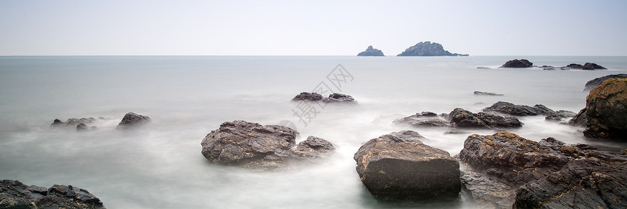 日出时岩石海岸线的全景景观背景图片