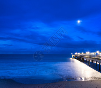 黄昏的码头景观延伸大海与月光图片