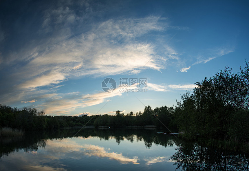 夏天的日落反射平静的湖水中图片