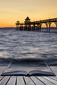 惊人的长曝光日落海洋上与码头剪影形象图片