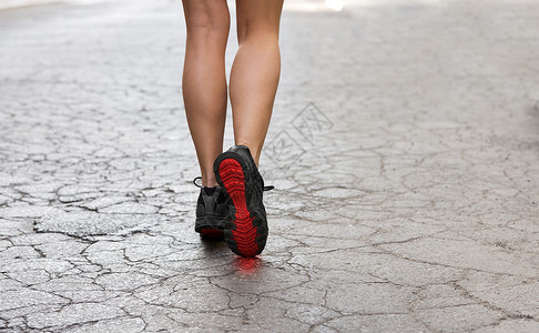 后镜头的轻女士带着健身鞋,条破碎的时尚道路上行走高清图片