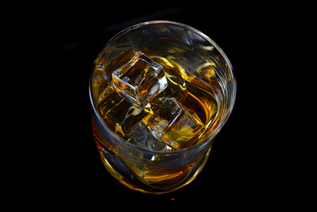 黑色背景上用简单的璃加冰的威士忌背景图片