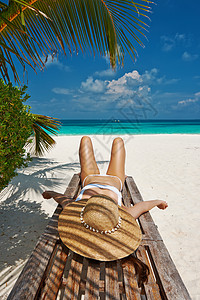 美丽海滩的女人躺躺椅上图片