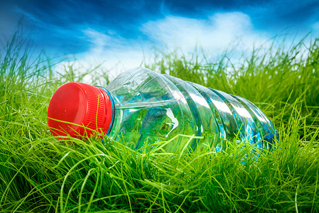 绿色草地上的瓶水高清图片