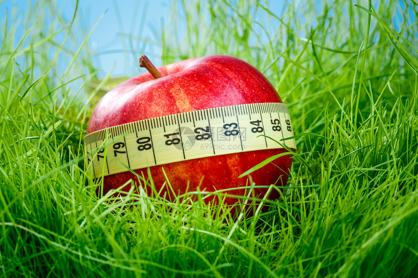 红苹果绿草地上的测量胶带图片