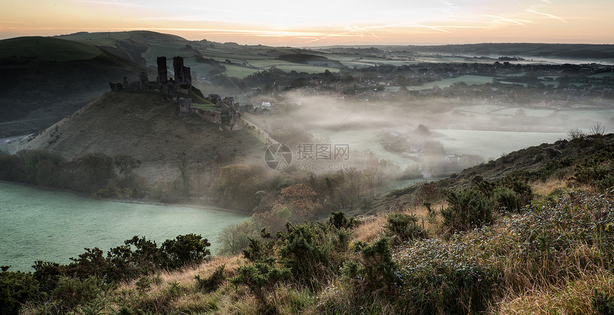 充满活力的日出中世纪的城堡遗址与雾乡村景观图片