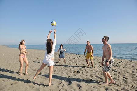 打排球的女孩轻人体玩得开心,阳光明媚的夏日打沙滩排球背景
