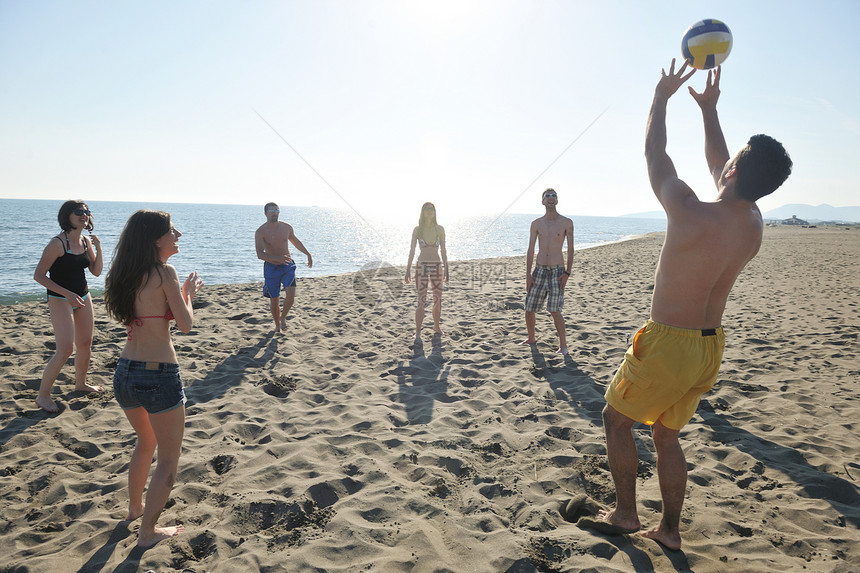 轻人体玩得开心,阳光明媚的夏日打沙滩排球图片