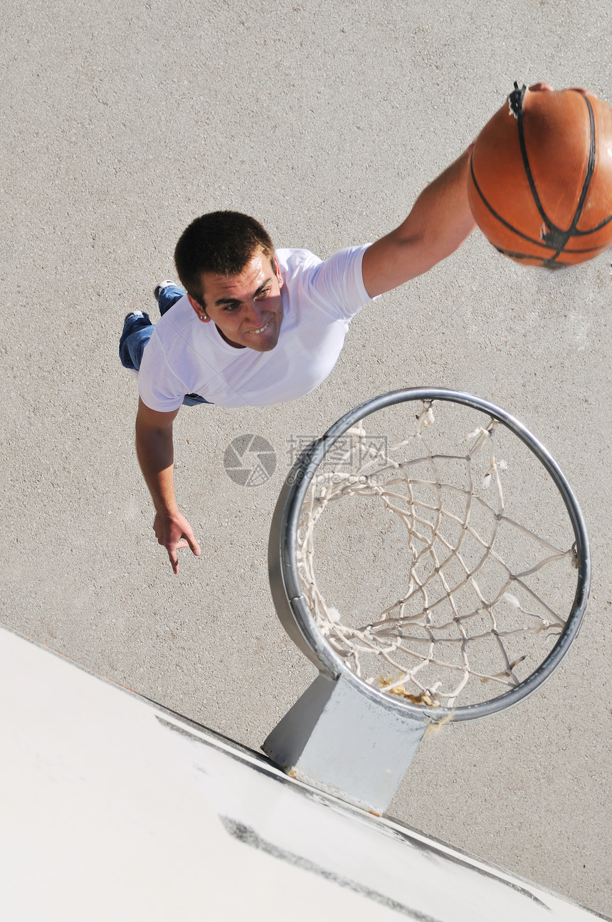 轻男孩户外打篮球,长阴影鸟瞰视角图片
