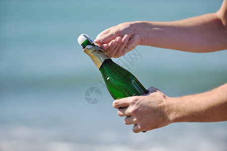 男子手打开瓶香槟酒葡萄酒饮料户外派庆祝活动图片