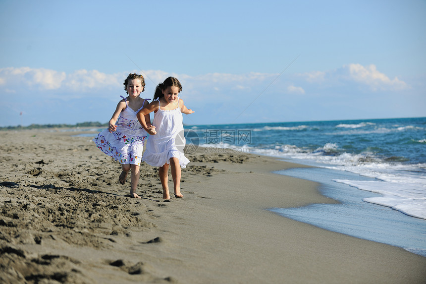 快乐的两个小女孩美丽的海滩上享受快乐快乐的时光,同时快乐中奔跑图片