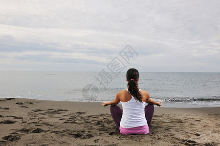 轻的女人清晨海滩上的莲花正丁冥想瑜伽高清图片