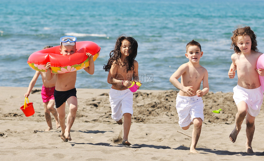 快乐的儿童小海滩上玩玩具跑步跳跃时玩得很开心图片