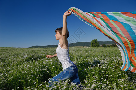 正风反腐轻的女人站麦田里跳跃奔跑,夏天的背景蓝天,代表着健康的生活农业理念背景