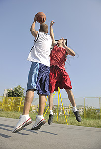 街球篮球比赛与两名轻球员清晨城市球场背景图片