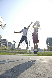 街球篮球比赛与两名轻球员清晨城市球场背景图片