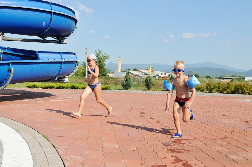 快乐的孩子们美丽的水上公园的室外游泳池里玩得很开心图片