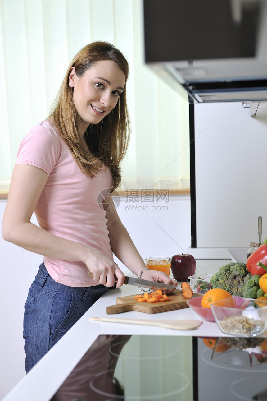 个快乐的轻女人,厨房里苹果其他食物蔬菜图片