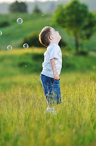 快乐的轻美丽的孩子Eadow上玩肥皂泡泡玩具图片