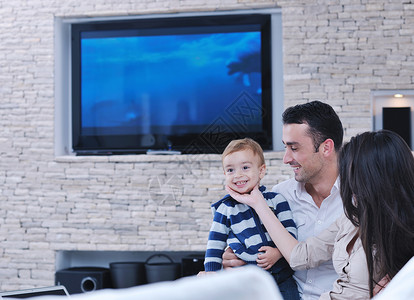孩子电视快乐的轻家庭新的家庭乐趣放松与现代液晶电视背景背景