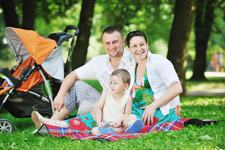 快乐的轻家庭公园放松,并与孕妇玩得开心图片