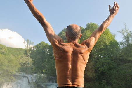 站立的人,张开双臂,背景瀑布,代表新鲜,健康的生活方式成功的图片