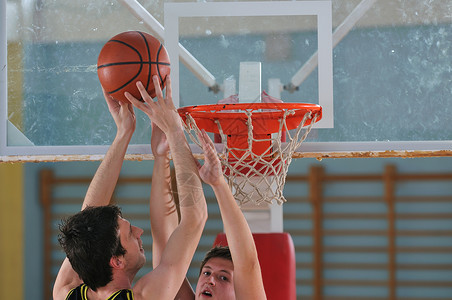 打篮球的男孩与学校健身房打篮球的人竞争背景