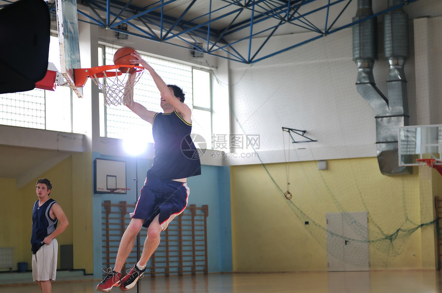 个健康的轻人学校体育馆室内玩篮球比赛图片